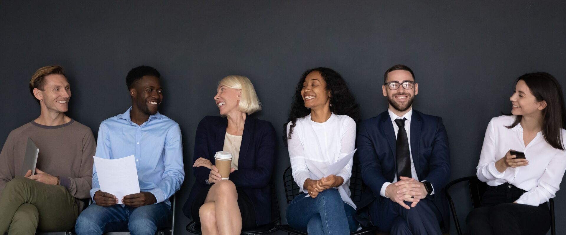 Overjoyed diverse job candidates have fun talking before interview